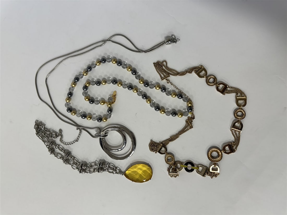 Collector or Dealer's Lot of Costume Necklaces (4): Modernist 50's silverplate necklace; large faceted amber pendant on an openlink silverplated chain; a sgd.Mark goldplated and yellow and black enameled long chain or belt; a marked Joan Rivers gold an