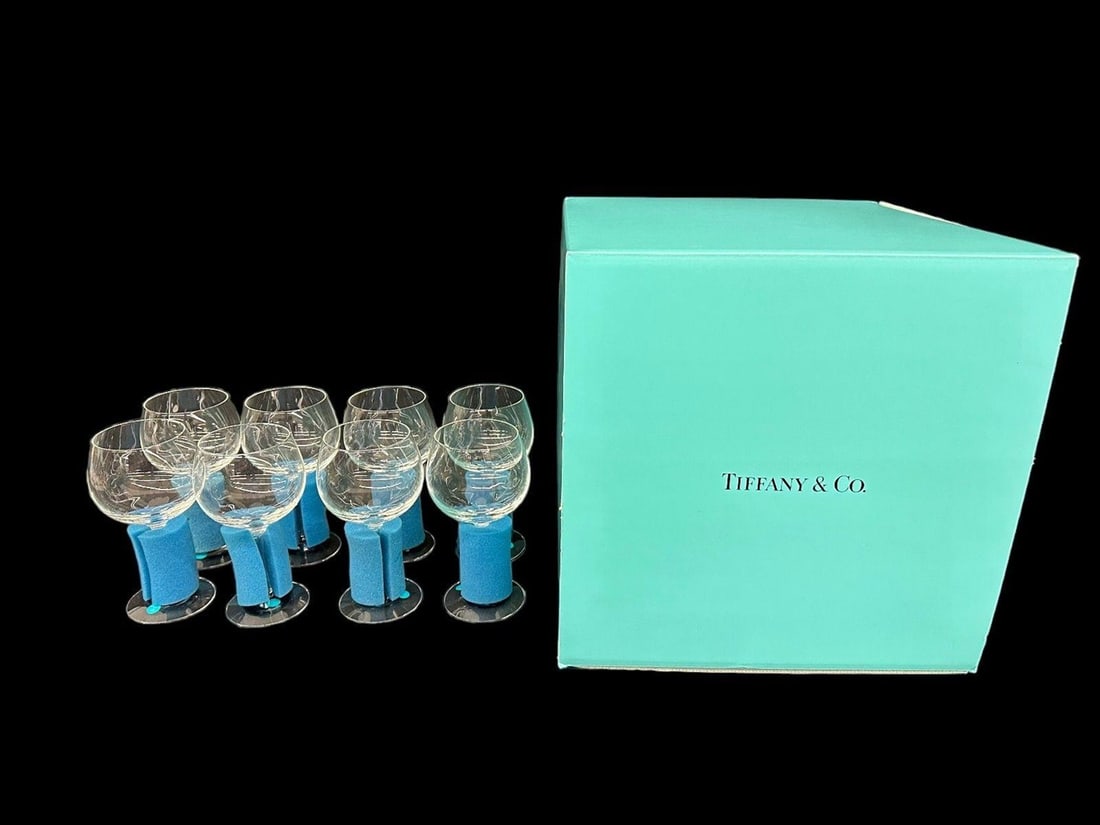 Tiffany & Co. Crystal Wine Glasses (8): New in the box with original wrappers and foam supports. Never used. Original as purchased. Note: Glasses are perfectly clear and flawless. Any marks seen in the photos are reflections. Eight in the l