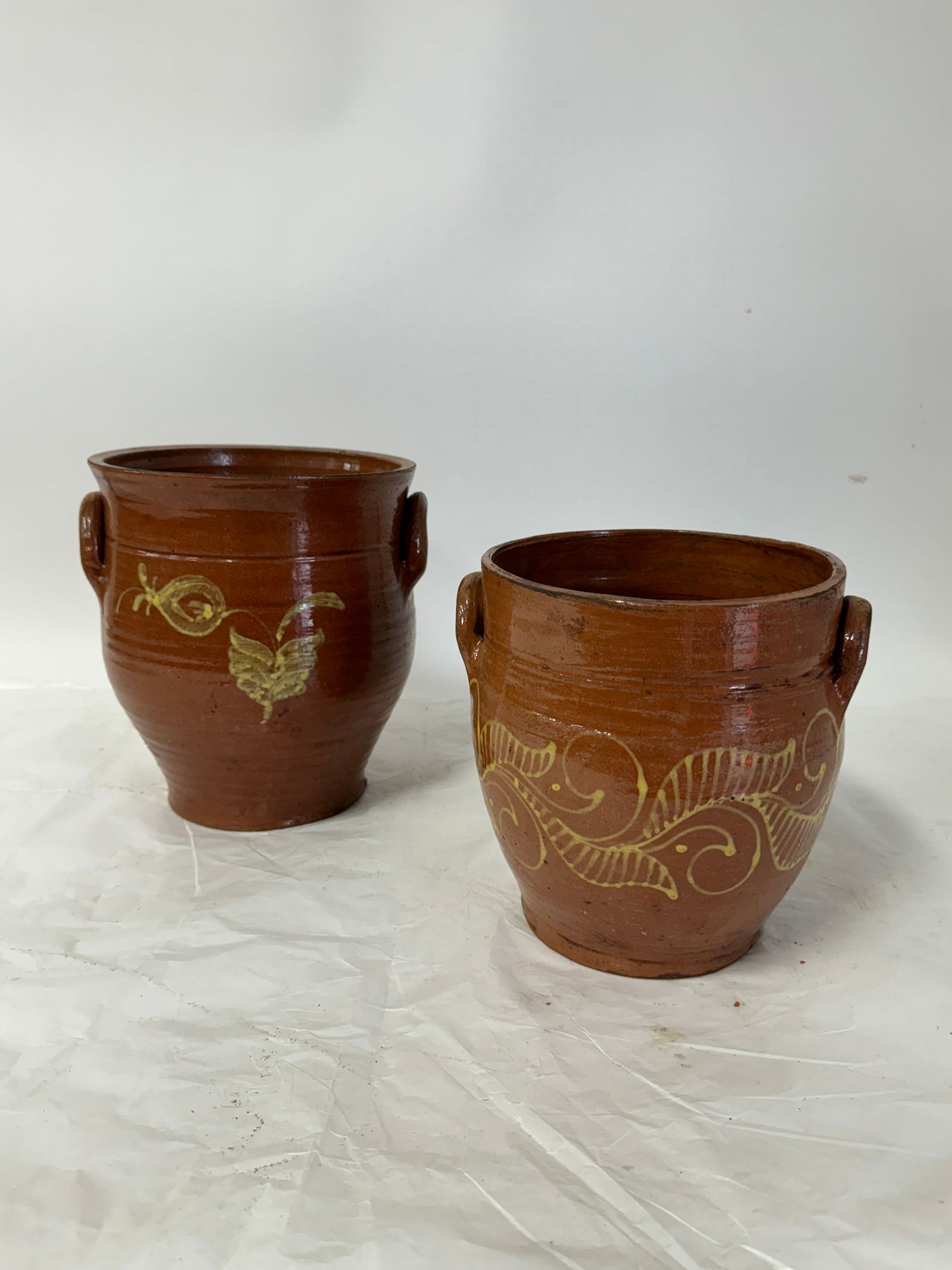Two(2) Redware Pottery Pots: Two(2) glazed pottery pots. Molded handles and slip decoration; 8.5in. - 10in.H.