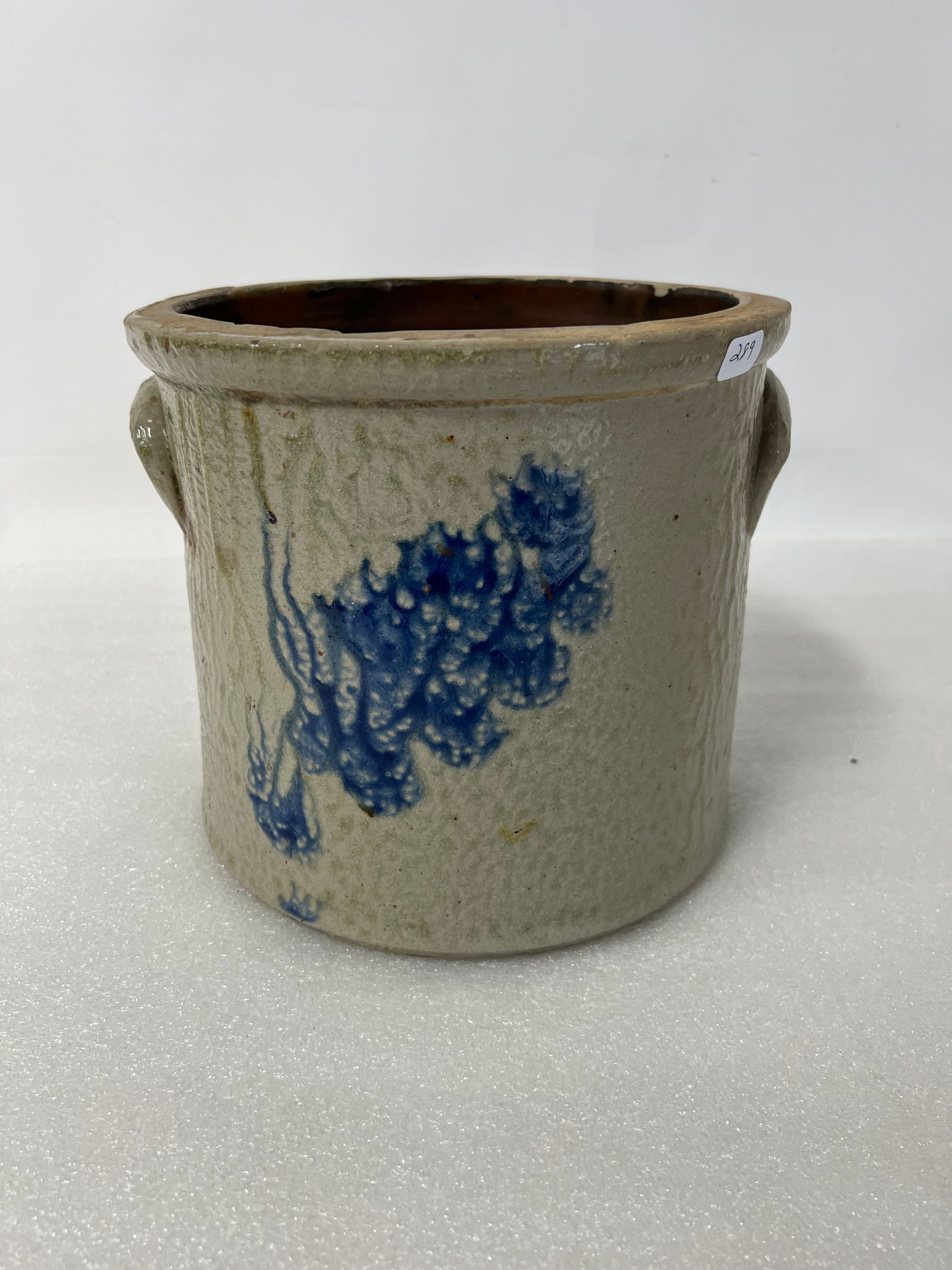 Blue Decorated Stoneware Crock: Double attached handles. Abstract blue floral or berry decorations. Wear and minor chips to the rim, 8"H 8 1/2"W