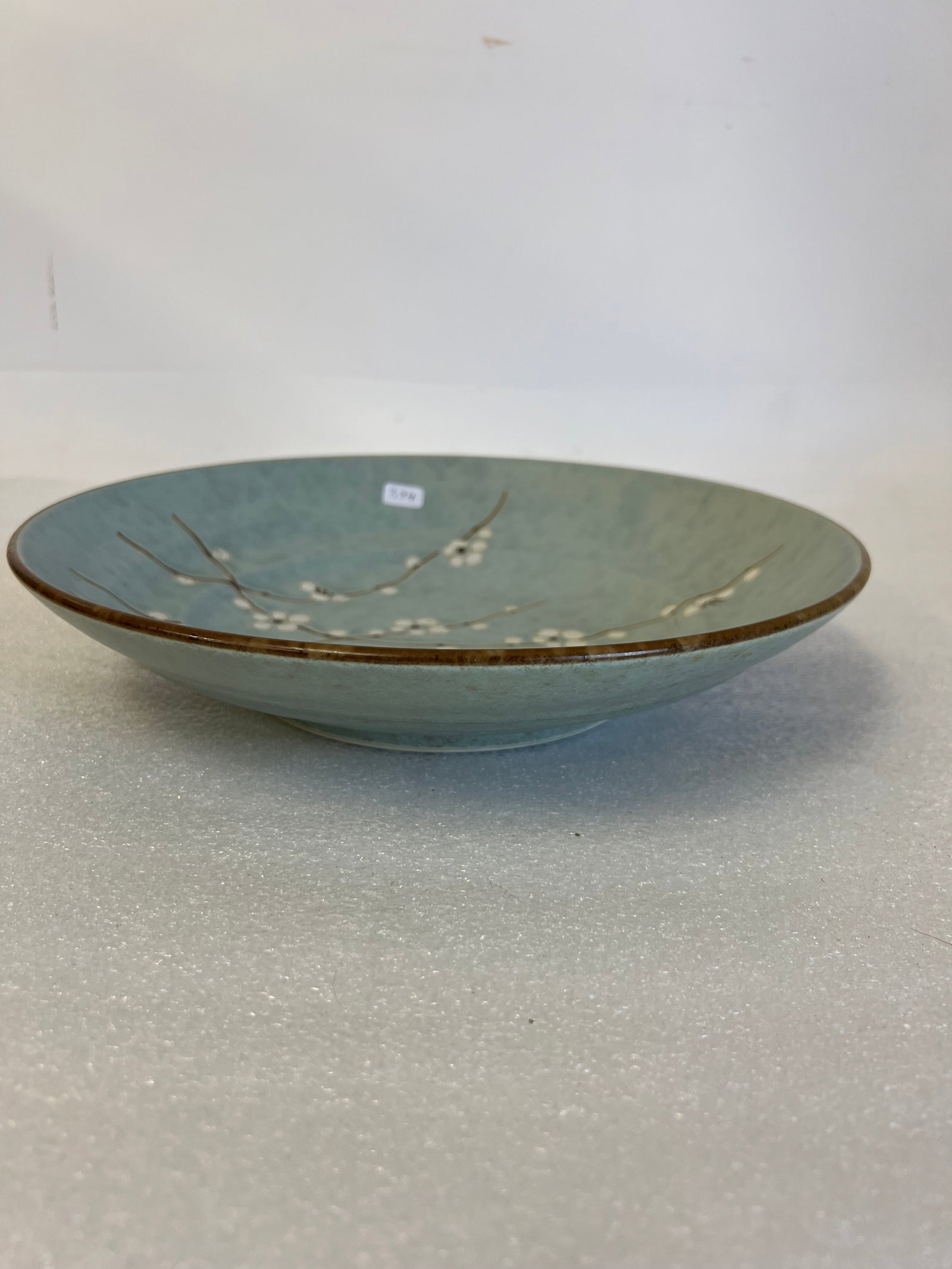 Antique Oriental Celadon Bowl.: Hand painted and decorated with dogwood. Oriental marking at the underside,11 1/4"W