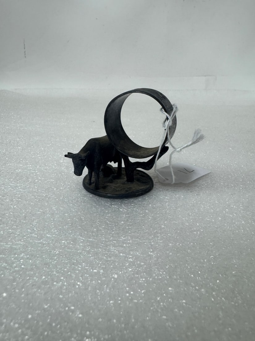 Figural Napkin Ring: Cow next to napkin ring on a circular base.