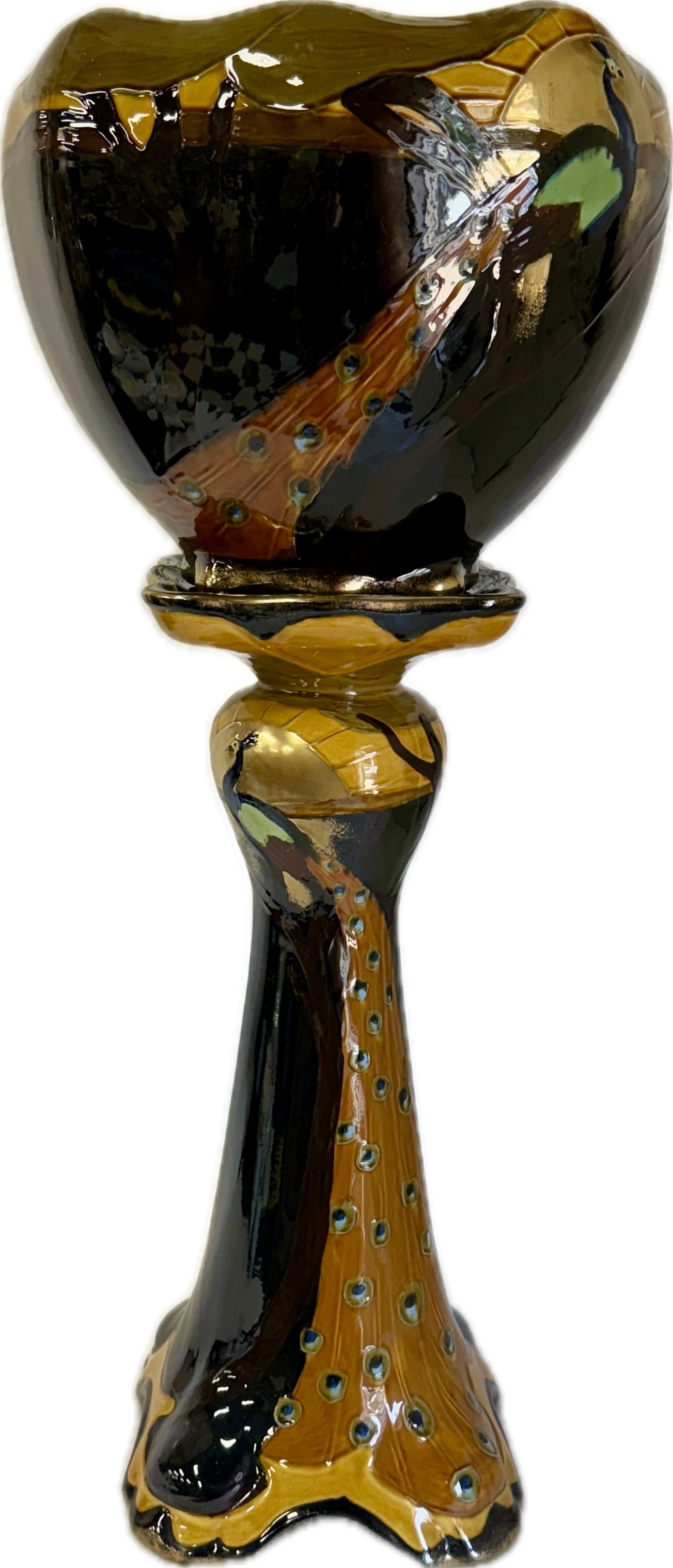 T.F. & S. Phoenix Ware Peacock Jardiniere and Pedestal: Highly glazed pottery jardiniere and pedestal. Depicting a peacock with flowing plume in a stylized landscape. 38in.H.(overall), 13in.H. x 15in.W.(planter)