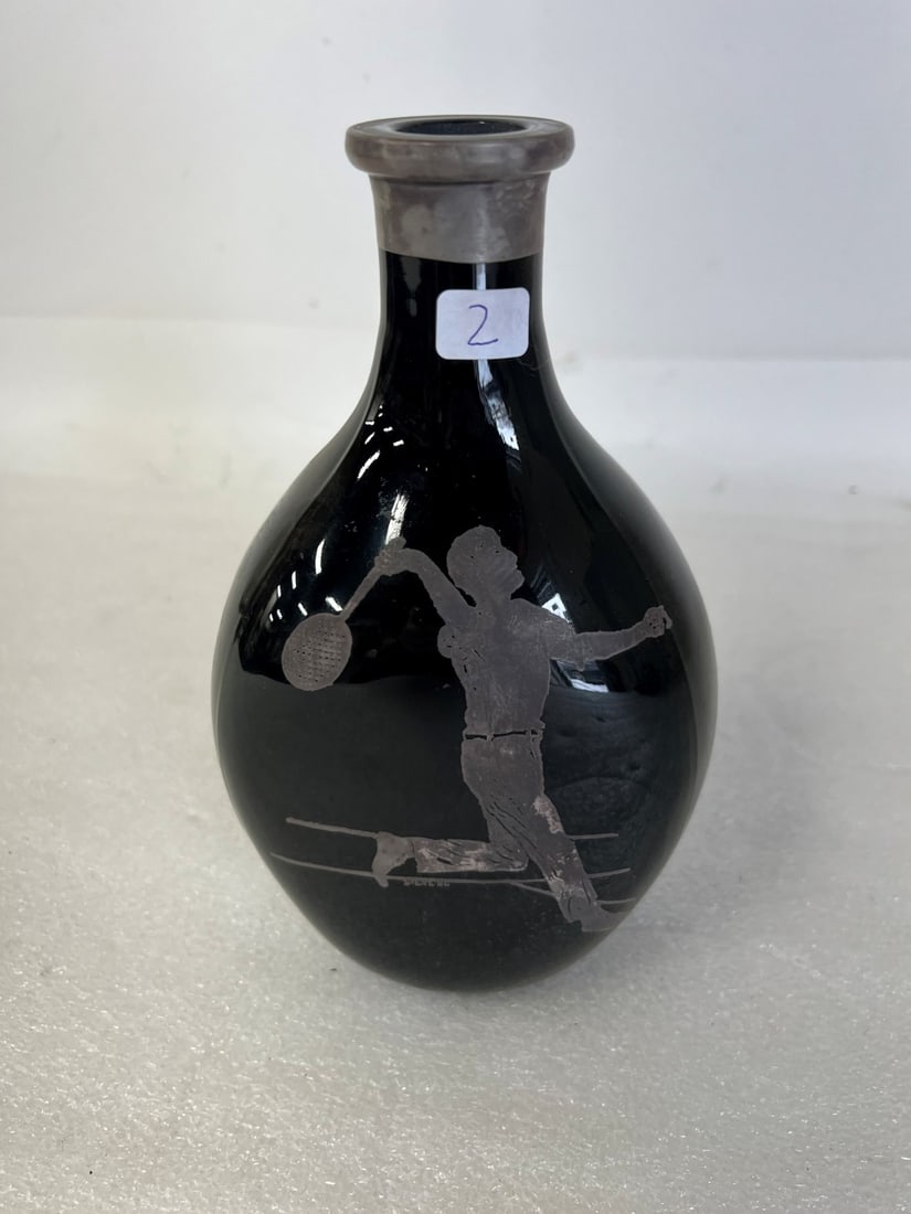 Vintage Black Glass Carafe with a Sterling Silver Overlay: The overlay features a tennis player motif, which is part of a broader "sporting" or "tavern" theme. 8"H by 4.5"W.