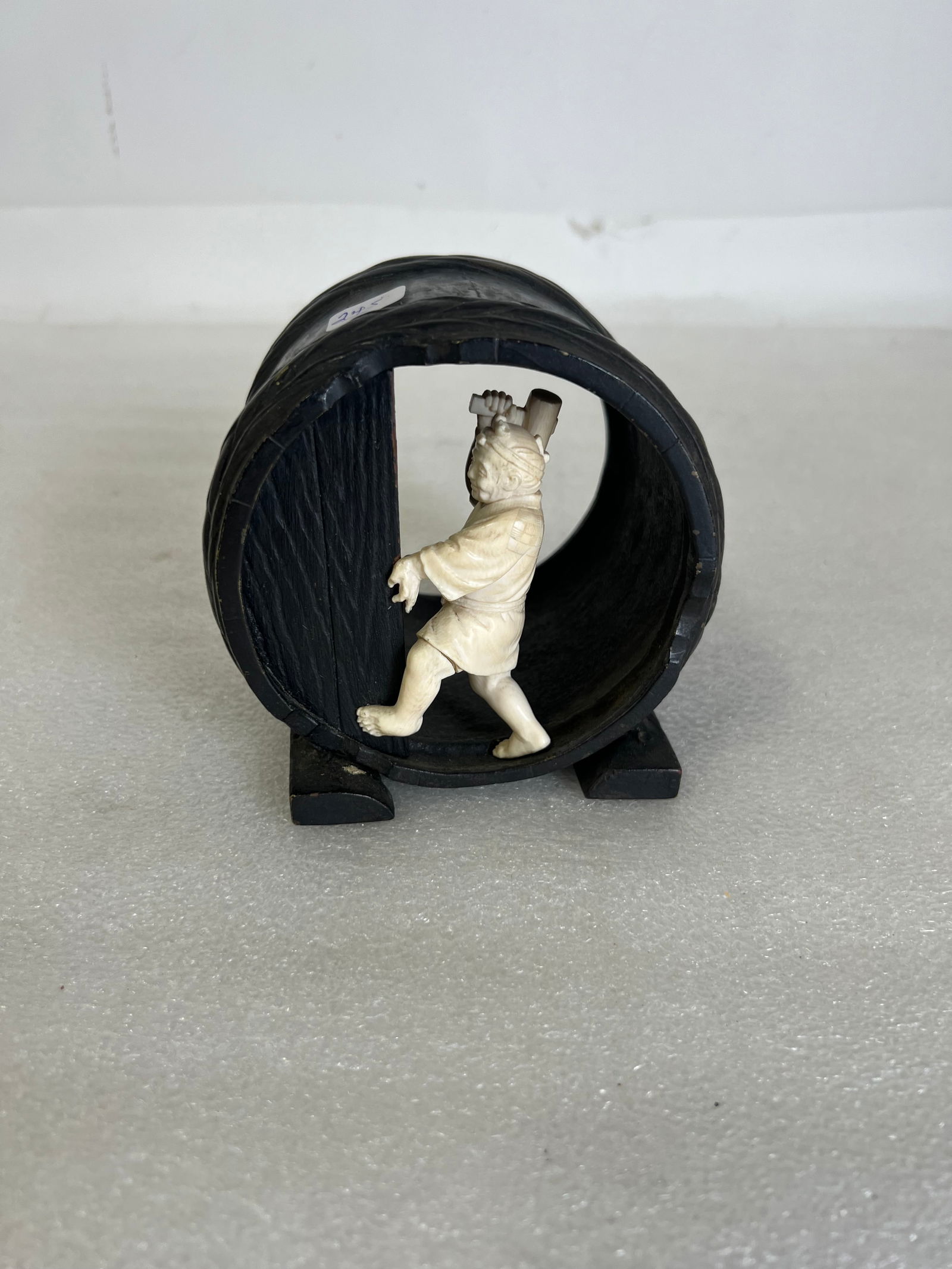 19th C. Bronze and Porcelain Figure: Porcelain Figure with Hammer inside Bronze Barrel.