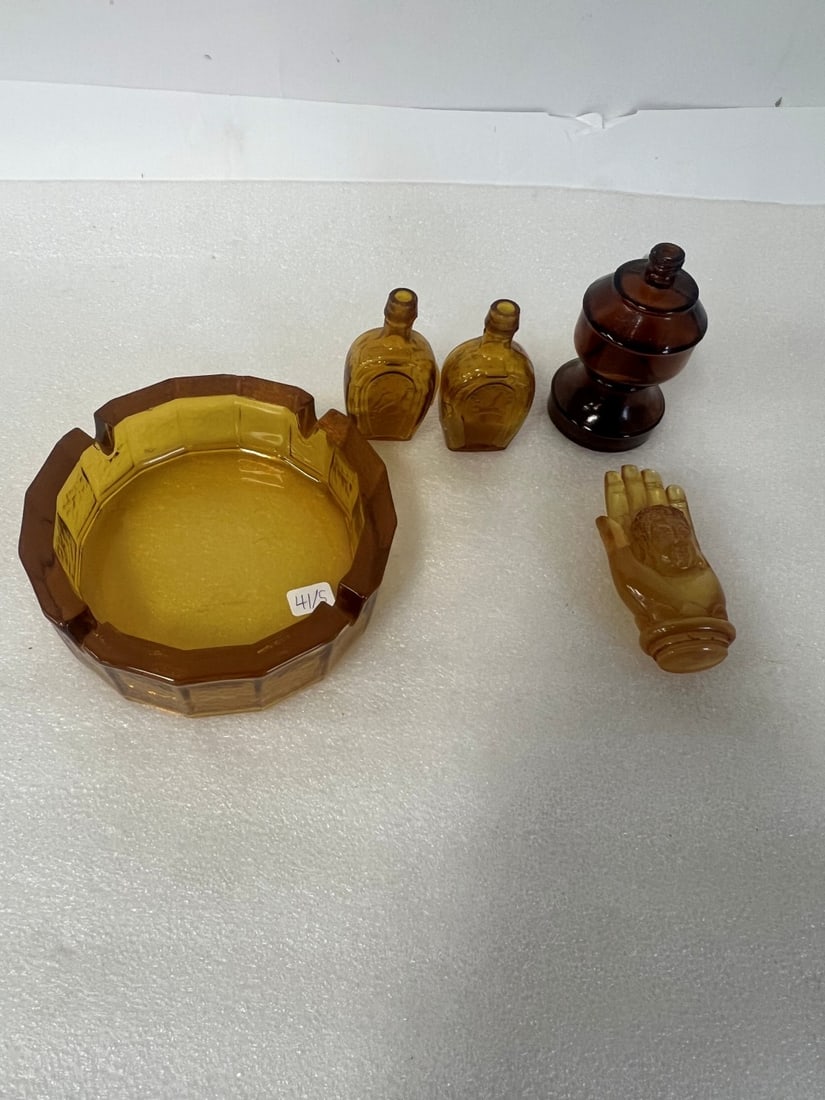 Brown and Amber Glass for Collector or Dealer: Miniature bottles marked Horseshoe (2) a Buddha head in hand figure; ; an ashtray, an Avon bottle in the shape of an oil lamp. 3" tp 4"