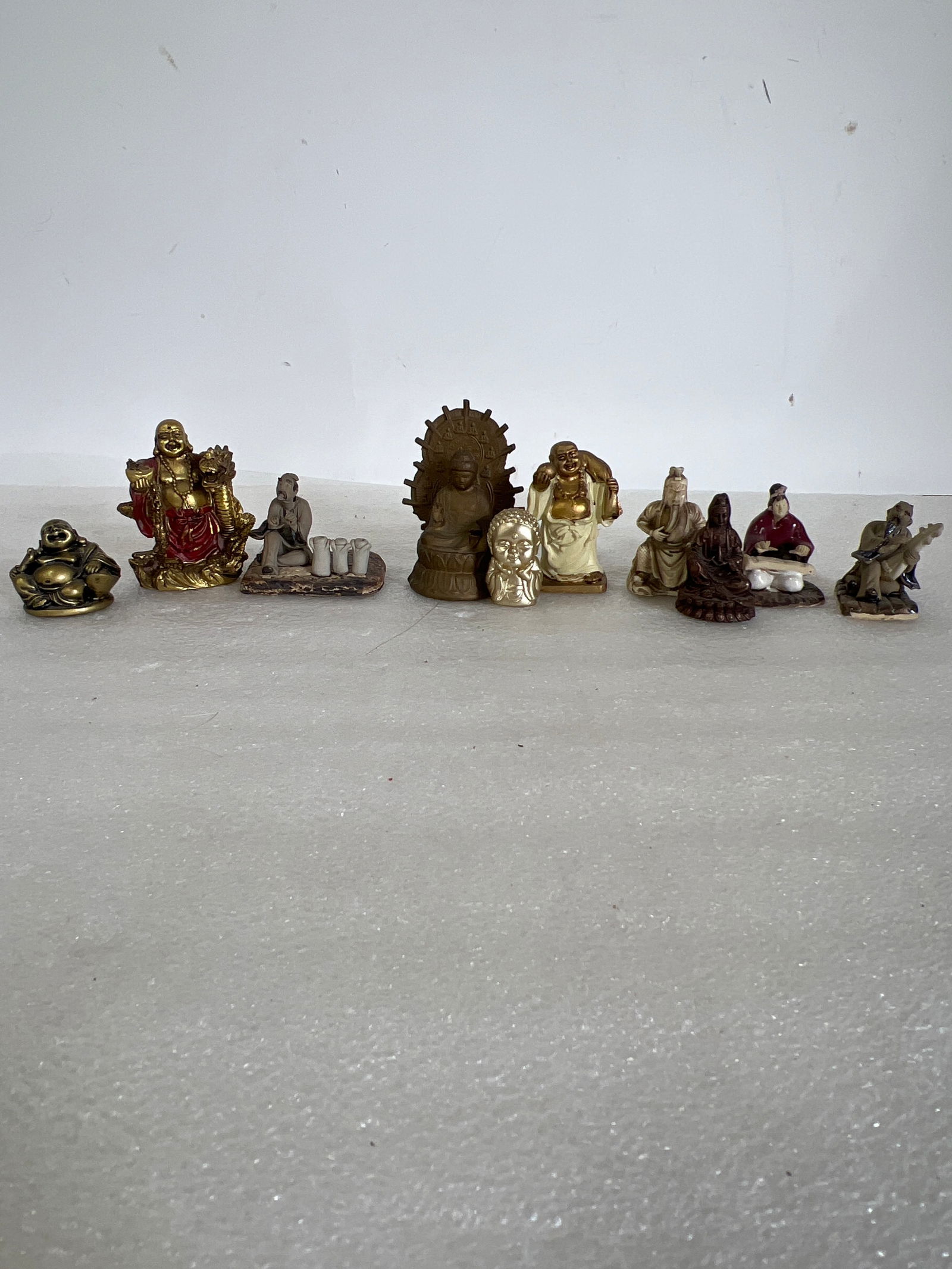 Lot of Oriental Figures (10): Lot includes pottery, brass, wood carved, various makes. Tallest in 3”H. Smallest is 1.25”H.