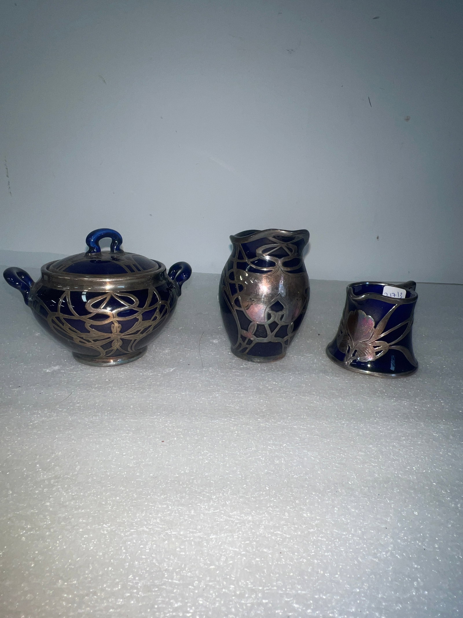Sterling Over Cobalt Creamers (2) and Covered Sugar (1): Two creamers and a covered sugar. As pictured. Tallest is 4”H. Smallest is 2.25”H.