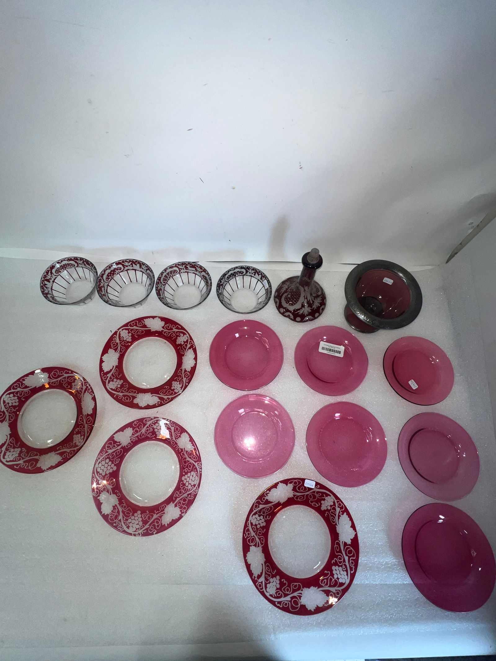 Collectible Lot of Ruby and Cranberry Glass ( 17 Pcs): Seven bread and butter plates; four etched decorated ruby plates; four bowls; an amethyst glass compote and a large stopper. 7 1/2"H (stopper) and 4 3/4"D to 8"D others. Seventeen in the lot.