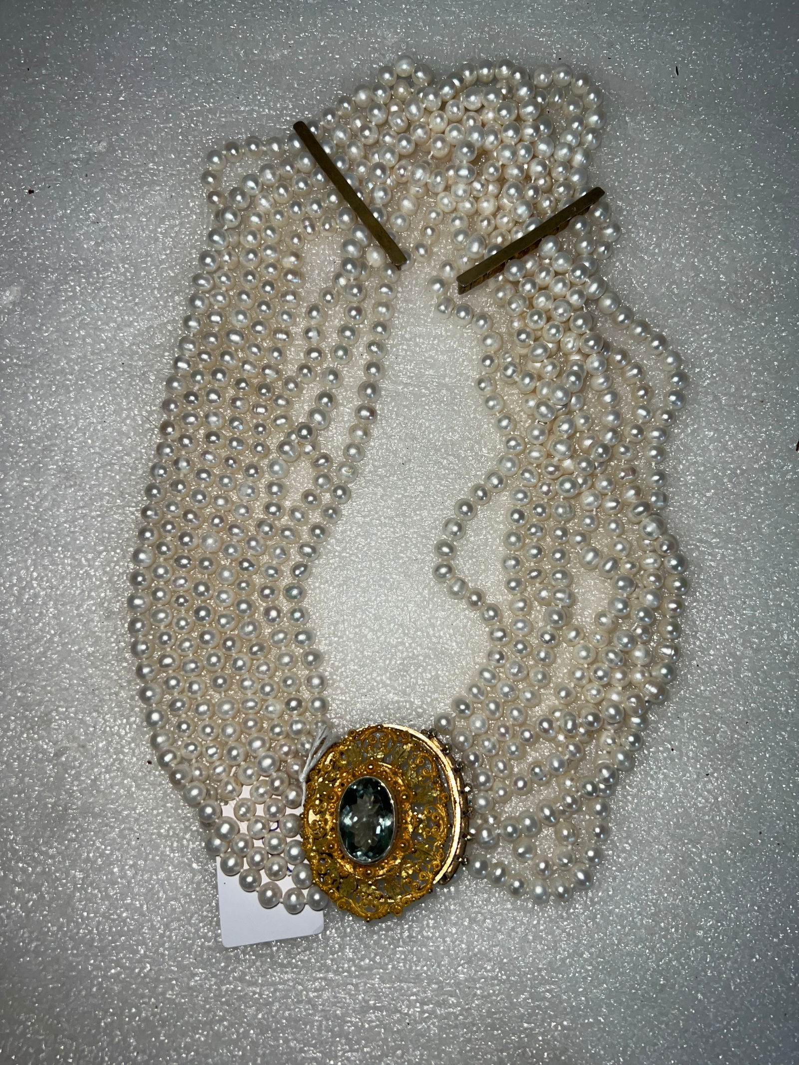 Eight Strand Vintage Pearl Costume Necklace.: With an ornate clasp, gilt surround to a multi faceted clear crystal stone.