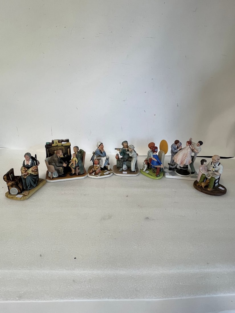 Collectible Lot of Norman Rockwell Figurines (7): As pictured. Seven in the Lot. Lot includes "The First Haircut", "Memories", "Exasperated Nannie", "Young Love", "The Toymaker", "Captain" and "First Annual Visit". Tallest is 7"H. Smallest is 5.25"H.