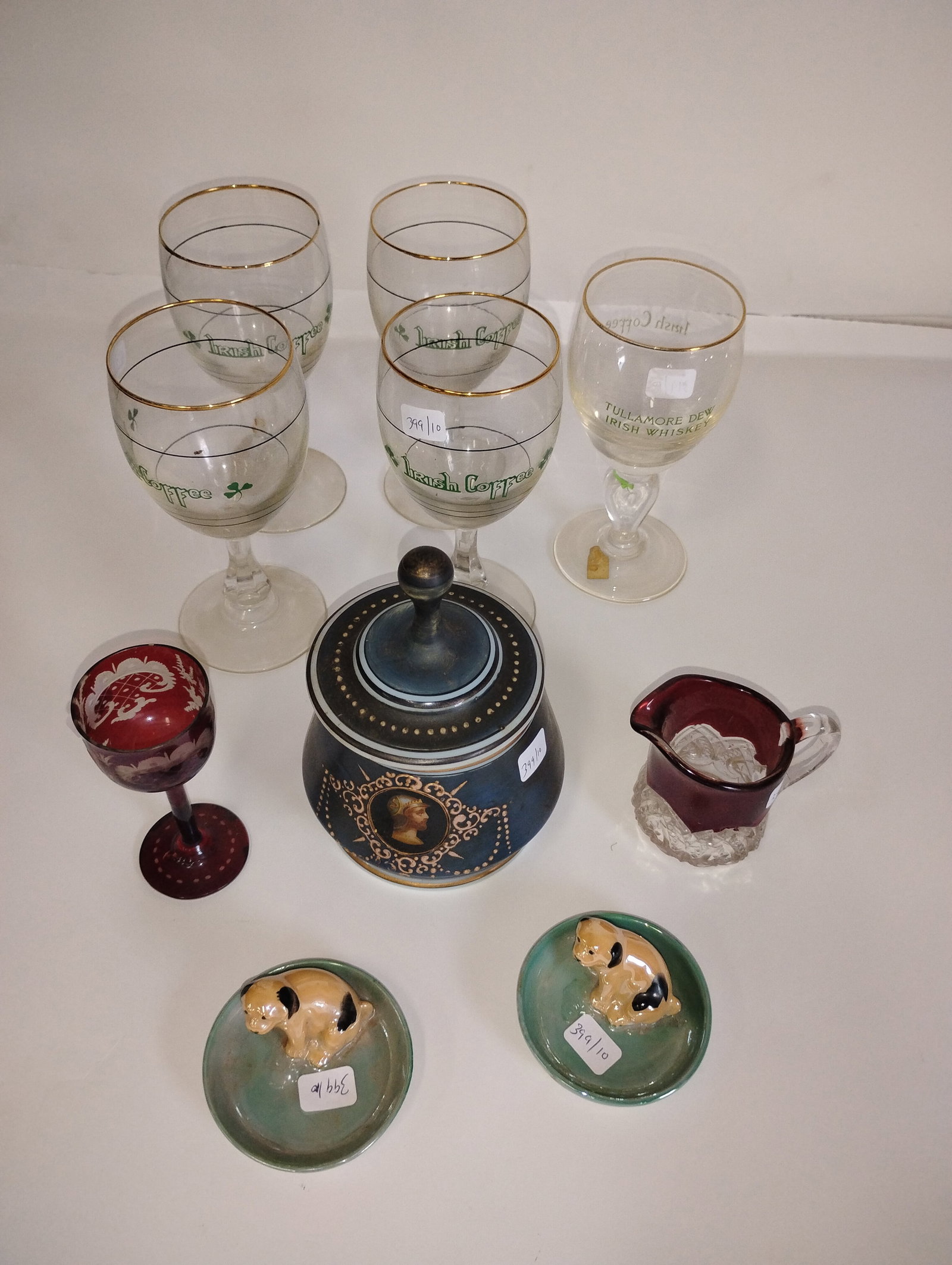 Dealers Lot of Antiques (10): A pair of Noritake Puppy Trays, a bohemian glass miniature pitcher and codial, a milk glass covered dish and 4 Irish Coffee stemed goblets. Also a Waterford Irish Coffee Stemed Glass. Tallest is 6"H.