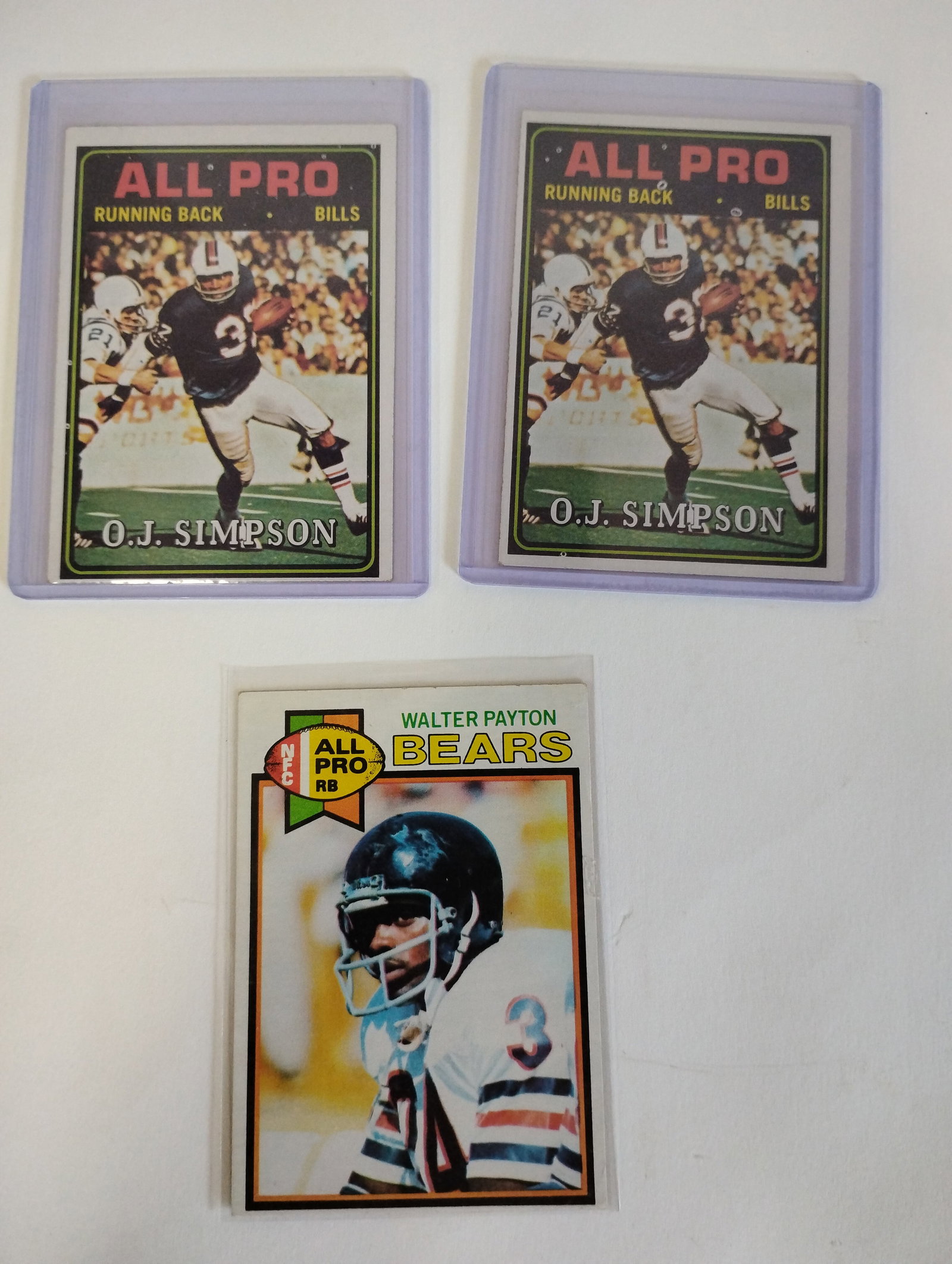 All Pro 1974/1979 Football Cards (3): 2 1974 O.J. Simpson and one 1979 Walter Payton. All in protective sleeve.