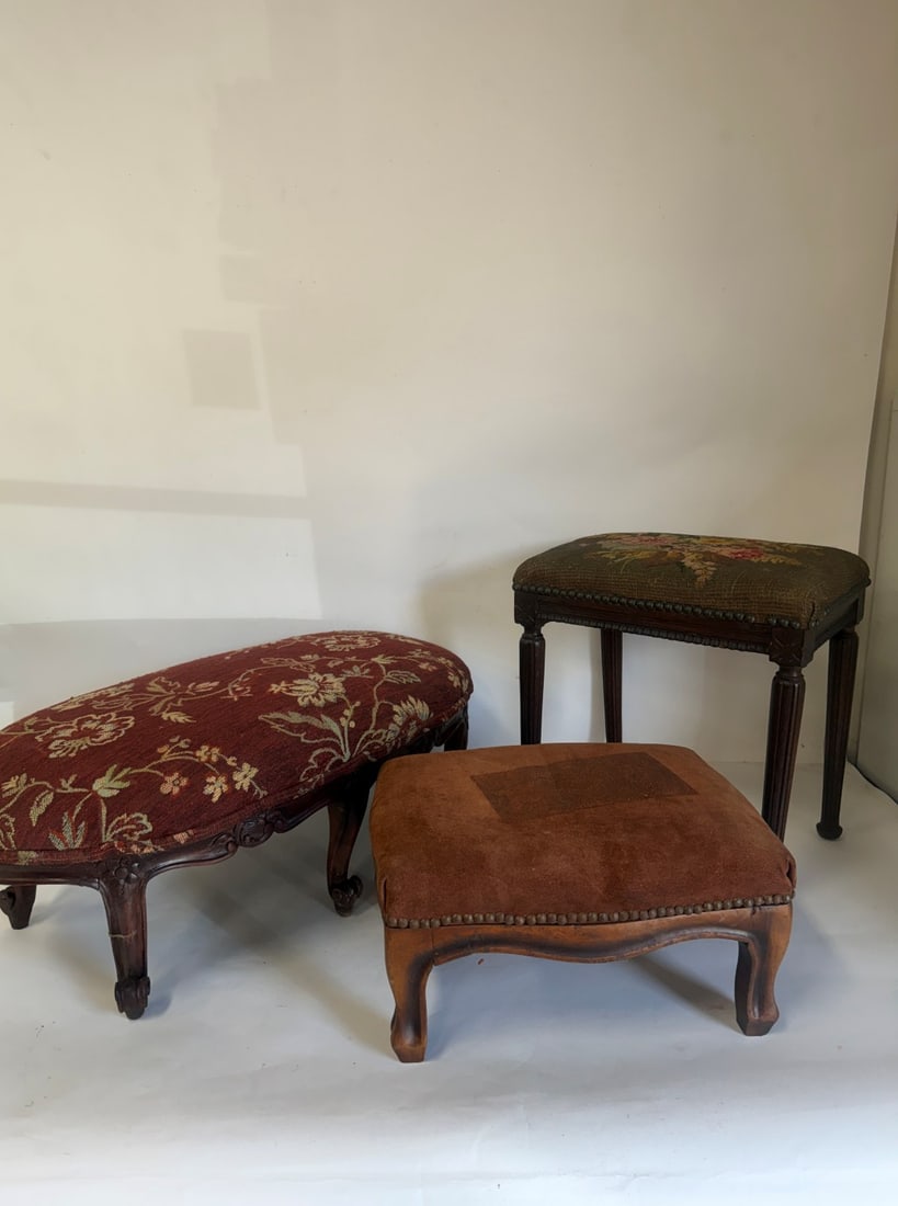 Vintage Footstools (3): Lot includes a tall needlepoint (15"H by 14.5"W). A short oval (10.5"H by 26.5"W) and a small brown (8"H by 15"W). Various sizes. As pictured