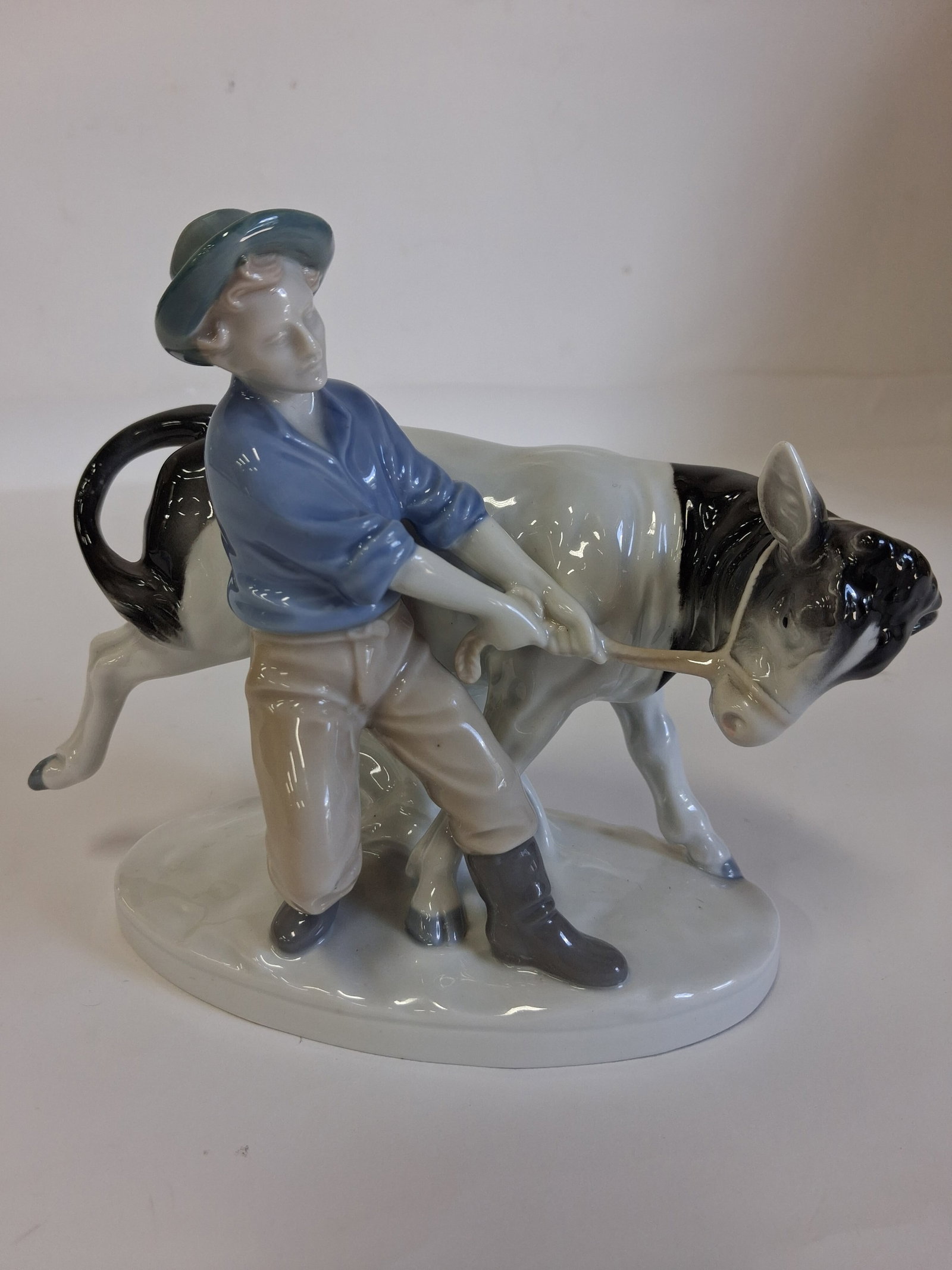 Royal Copenhagen Like Porcelain Figure.: Young man with a resisting cow. Crown and S mark as pictured7in H x 8 1/2" w