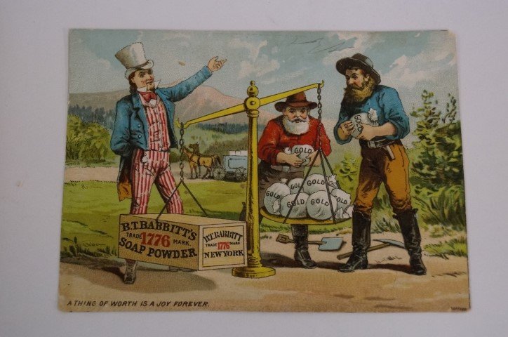 Babbitt's Soap Powder Trade Card: "A Thing of Worth is a Joy Forever" Depicts Uncle Sam overseeing the weighing of a prospector's gold bags against the B.T. Babbitt's Soap Powder Box which is outweighing the gold miners' load. Verse a