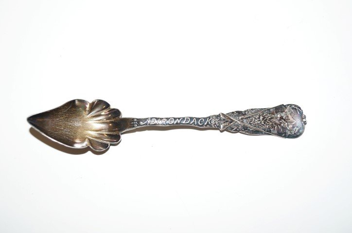 Sterling Silver Souvenir Spoon: Unusual Adirondack themed sterling silver souvenir spoon or hunting themed. Marked Adirondack on the handle amidest an antlered elk and crossed rifles. 6"