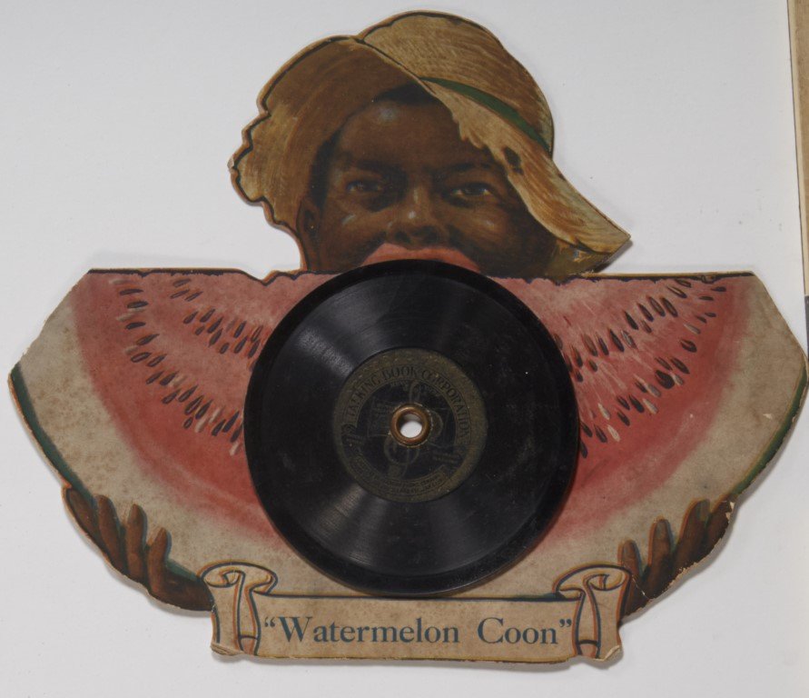 Talking Book Company Advertisement: From The Talking Book Company. Lithography on cardboard. Faux vinyl spinning record attached.; 7 3/4" x 9 3/4"
