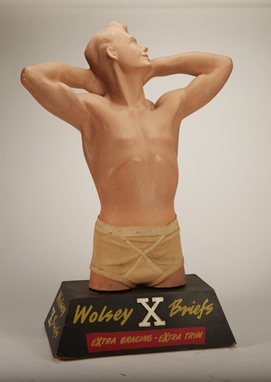 Wolsey X Briefs: Extra Bracing - Extra Trim" Male figure wearing briefs. Plaster figure, wooden base.; 29" x 16
