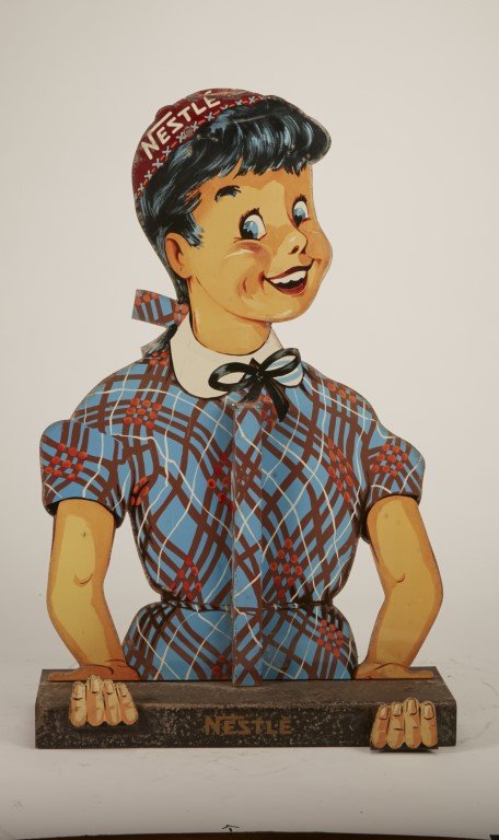 Nestle Metal Cut-out Display: Die-cut female character. Lithography on metal. ; 20 1/2" x 13"