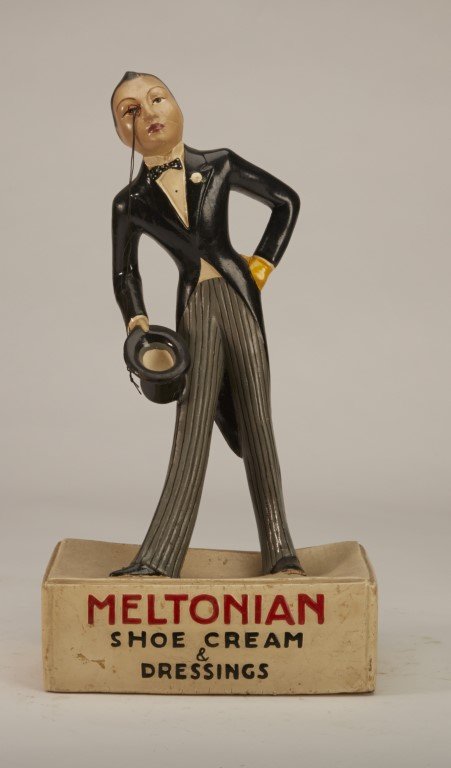 Meltonian Figural Display: Shoe Cream & Dressings" . Featuring man in tuxedo holding a top hat with monical. Painted plaster. ; 15 1/2" x 8