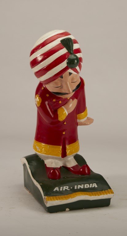 Air India Flying Carpet Statue: Depicts a man on a flying carpet bowing. Painted Paper mache. Manufactured by Bandivdekar Compaper Crafts Made in India. ; 12" x 6 1/2"