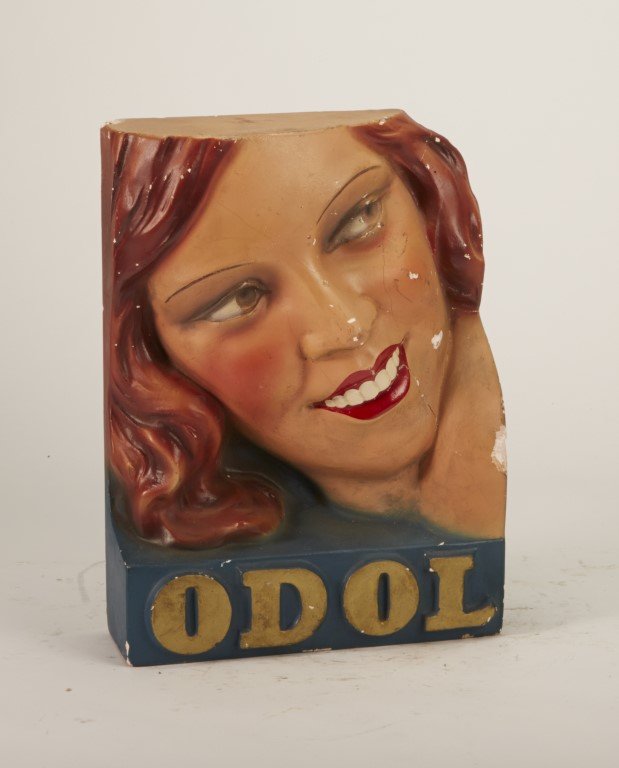 Odol Shelf Display: Depicts smiling woman with red lipstick. Painted plaster. A few cracks and chipping.; 11" x 8 1/2"