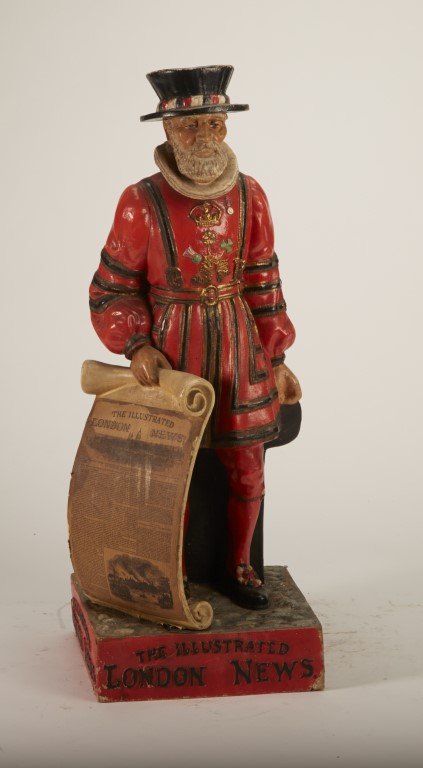 The Illustrated London News Figurine: Depicts a Beefeater holding a newspaper. Produced by PM Ltd. English. Condition: Some paint chipping. Painted plaster. ; 20" x 7"
