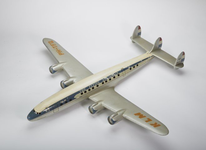 The Flying Dutchman Model Plane: KLM- Royal Dutch Airlines Scale 1-125 model. Lockheed L-1049 Super Constellation PH-TFQ. Manufactured by Raise Up Rotterdam, Holland. Condition: Scratching and minor paint loss. ; 26 1/4" x 28 1/4"