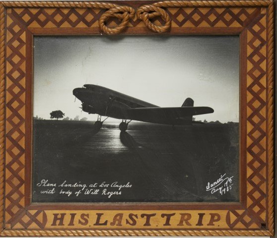 Photograph. "His Last Trip" 1935: Plane landing at Los Angeles with body of Will Rogers. Sunset 8/19/1935. Inlaid frame made for photo.; 15" x 17 1/4"
