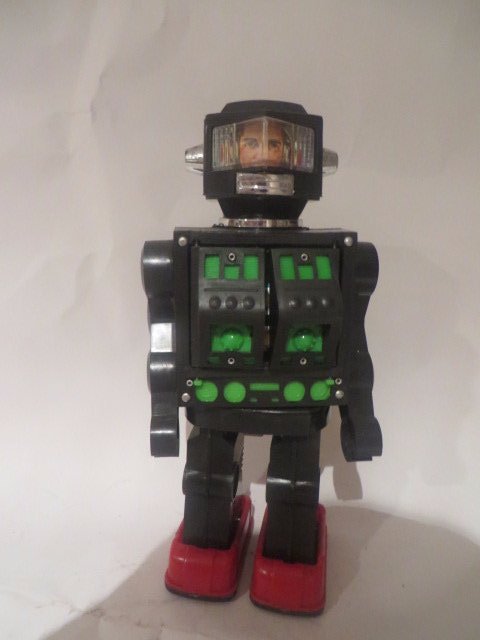 Robot Toy: Battery Operated. Front panels open to reveal lights and more mechanisms. "Human Face" appears through window. 12"H.