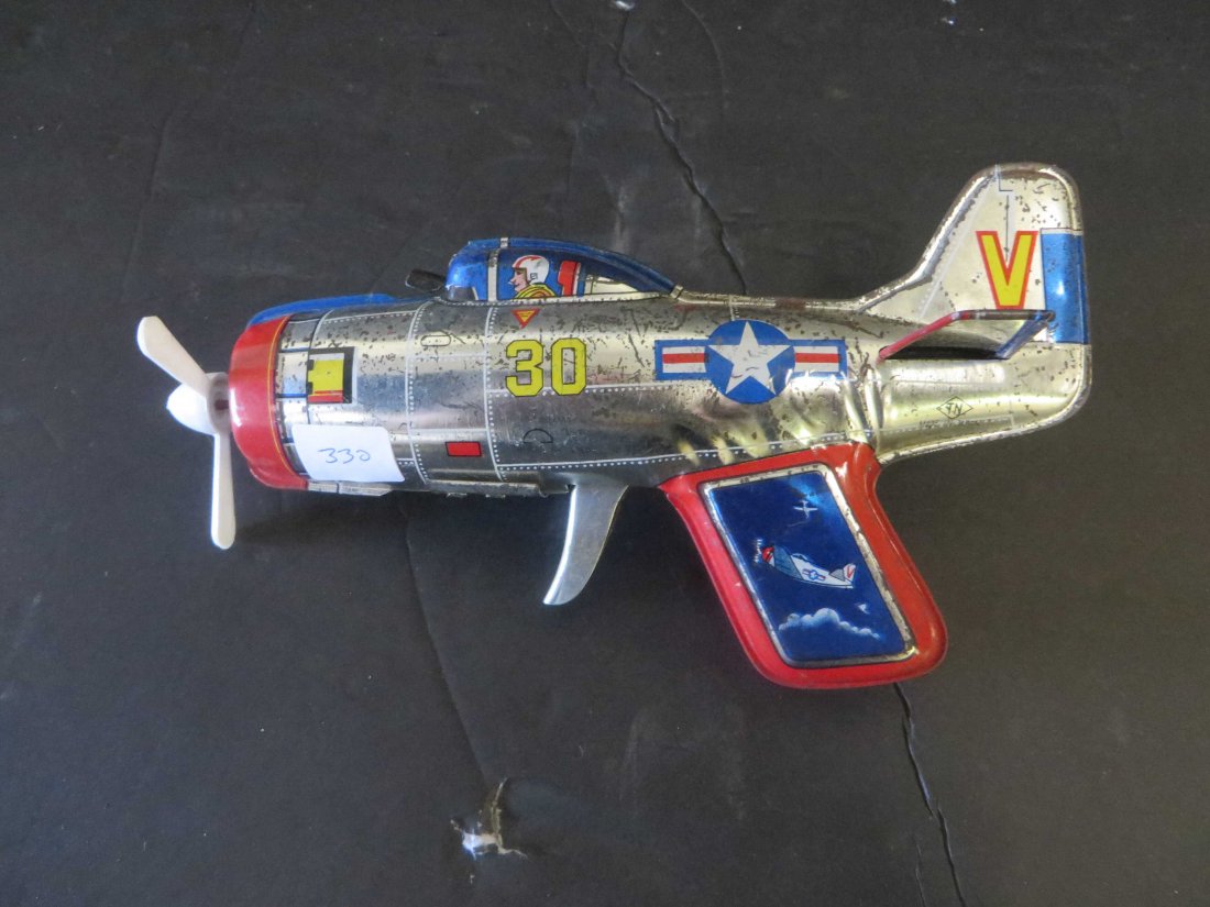 Friction Airplane Gun Toy: Handle pulled creates turning propellor flashing lights from pilots window. Paint quite worn on one side which will be visible in photo.