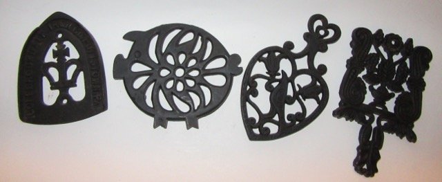 Cast Iron Lot (4): Trivets, sadiron holder . One marked Distelfink; one marked T-4 Grape; one marked Colebrookdale Iron Co. Pottstown, Pa.