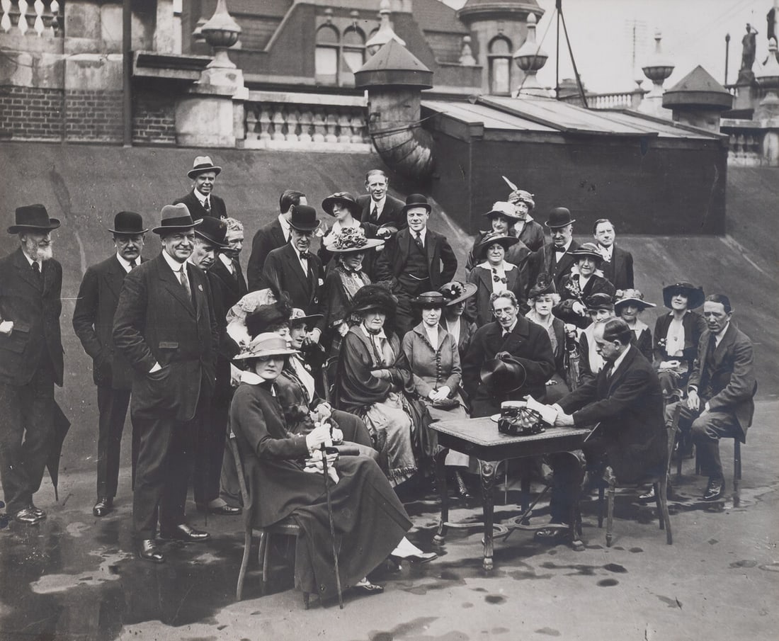 Photograph of J.M. Barrie reading to a group of writers and actors, including Gerald du Maurier,: Photograph of J.M. Barrie reading to a group of writers and actors, including Gerald du Maurier, Ellen Terry, George Bernard Shaw, George Grosmith, and others on the roof of the Wyndham Theatre, l