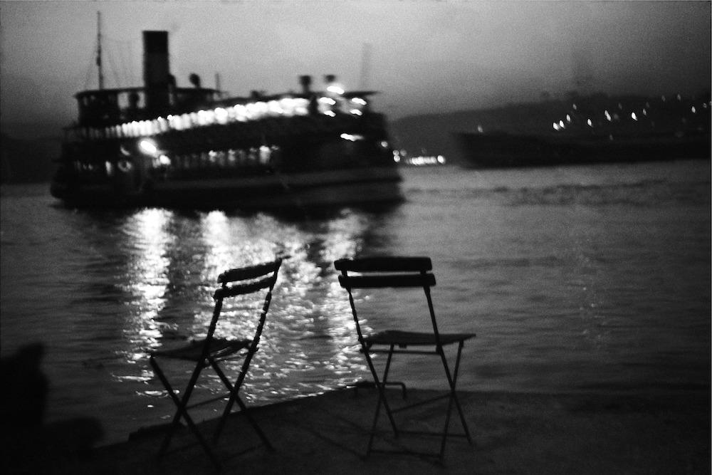 Ara Guler (1928-2018) Istanbul B&W Photo: Ara Guler (Turkish/ Armenian, 1928-2018) 'Istanbul' (Chairs & ferry) 9 3/8" x 13 3/4" (24cm x 35cm). Labelled on the back. Photo originally taken in the mid 1950s, this is a later print. Photo print o