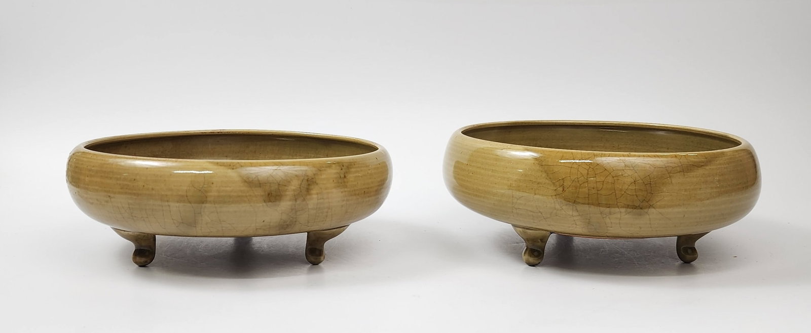 Chinese Olive Green Crackle Glazed Tripod Footed Bowls: Chinese Olive Green Crackle Glazed Tripod Footed Bowls, d. 8.5 inches, h. 3.25 & 3.75 in., circa 20th century. Provenance: Estate of a New York collector/ dealer. The collection assembled between earl