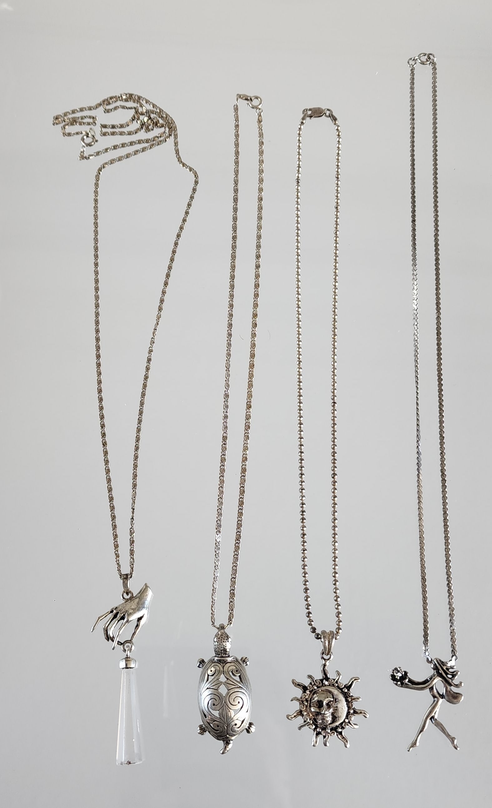 Group of Estate Vintage Sterling Silver Pendant Necklaces: Group of Estate Vintage Sterling Silver Pendant Necklaces . Four pendants, including; sun & moon, turtle, woman carrying a flower & hand holding crystal. Marks: 925, Jezlaine/ 985, 925/ Italy, 925/ Ma
