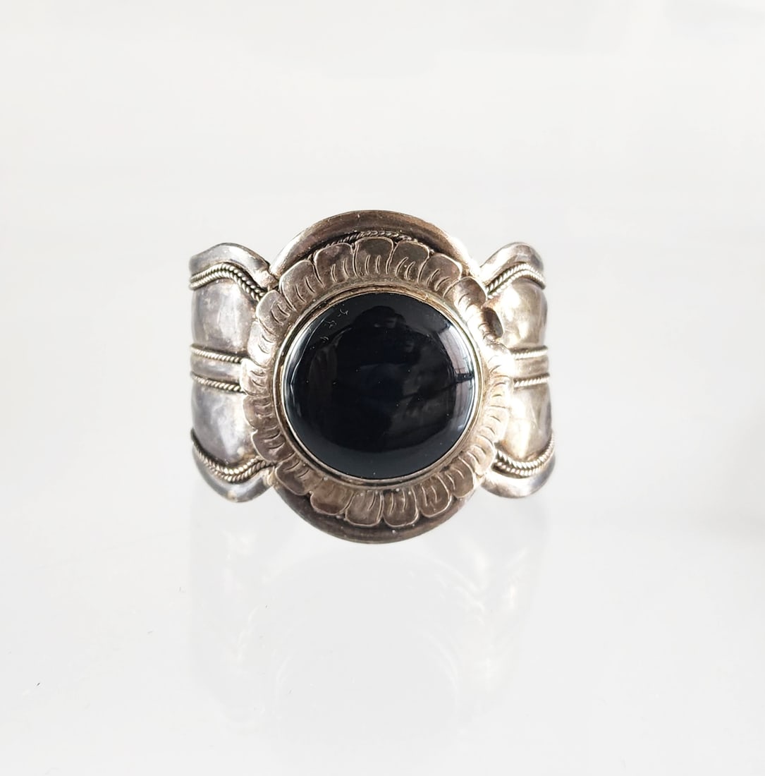 Estate Antique Sterling Silver Repousse & Black Onyx Wide Cuff: Estate Antique Sterling Silver Repousse & Black Onyx Wide Cuff, ca. 20th century. Marks: 925 Total weight: 55.4 grams. Provenance: Estate of Victoria Salter (1944-2024) Victoria Salter was the daughte