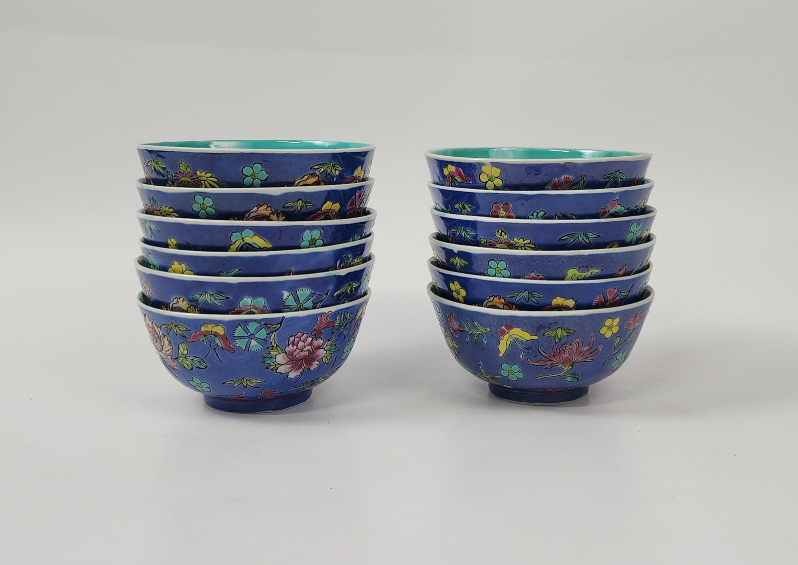 Set of 12 Chinese Export Famille Rose Blue Ground Enameled Bowls: Set of 12 Chinese Export Famille Rose Blue Ground Enameled Bowls with turquise enameled interiors , h. 2.25 inches, d. 4.5 inches, stamped Decorated in Hong Kong, , circa mid 20th century. Provenance: