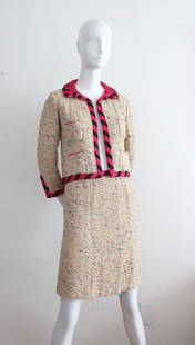 A Fine Chanel Haute Couture Tweed Skirt Suit, 1962: A Fine Chanel Haute Couture Tweed Skirt Suit with Black & Pink Striped Trim, 1962. Labelled 'Chanel' and hand numbered '18015'.