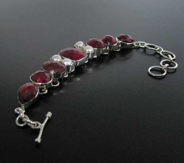 APP: 18k 46CT Ruby w/Pearls & Sterling Silver Bracelet: 46.90CT Ruby With Pearls and Sterling Silver Bracelet - Appraisal Value: $18.5K - Bid with utmost confidence from GovernmentAuction.com. We have been in business for over 35 years, and pride ourselves