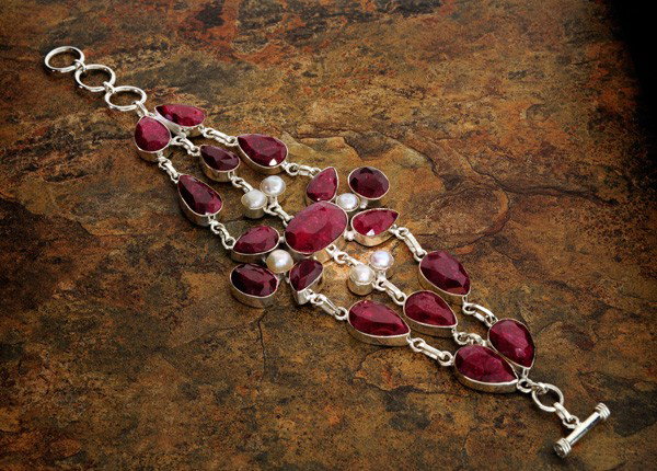 APP: 18k 104CTRuby w/Pearls & Sterling Silver Bracelet: 104.20CT Ruby W/ Pearls and Sterling Silver Bracelet - Appraisal Value: $18.9K - Bid with utmost confidence from GovernmentAuction.com. We have been in business for over 35 years, and pride ourselves 