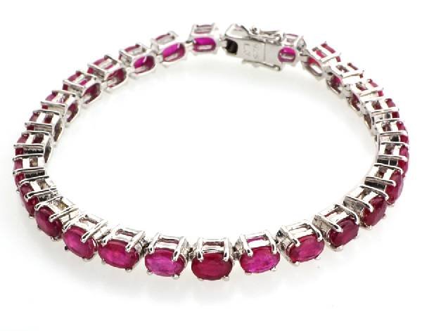 APP: 9k 12CT Oval Cut Ruby & Sterl Silver Bracelet: 12.26CT Oval Cut Ruby and Platinum Over Sterling Silver Bracelet - Appraisal Value: $9.6K