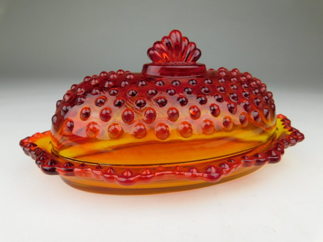Fenton Hob Nail Butter Dish: This Fenton Lidded Butter Dish is orange in color with the hob nail design. Base of dish is clear then fades to orange at the rim. (4x8x3)