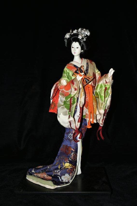 Hand Made Japanese Ceremonial Geisha Doll Dressing In a: Hand Made Japanese Ceremonial Geisha Doll Dressing In a beautifully multi colored kimono, dancing and using a drum. 17" Tall. Minor dusting from age. Likely circa 1970's.