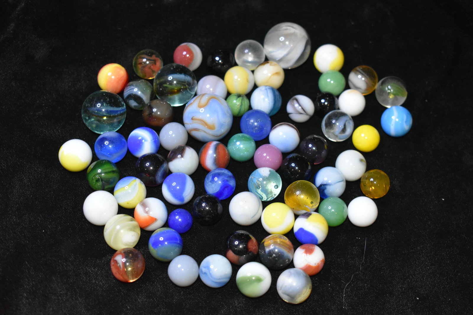 Pile of Over 65 Old Marbles: Pile of Over 65 Old Marbles Over 65 unsorted marbles going back as far or further than the 1950's. Various makers. Akro Agates, Peltier, Vitro, Alley, etc etc. Various sizes ranging up to 1" Shooters.