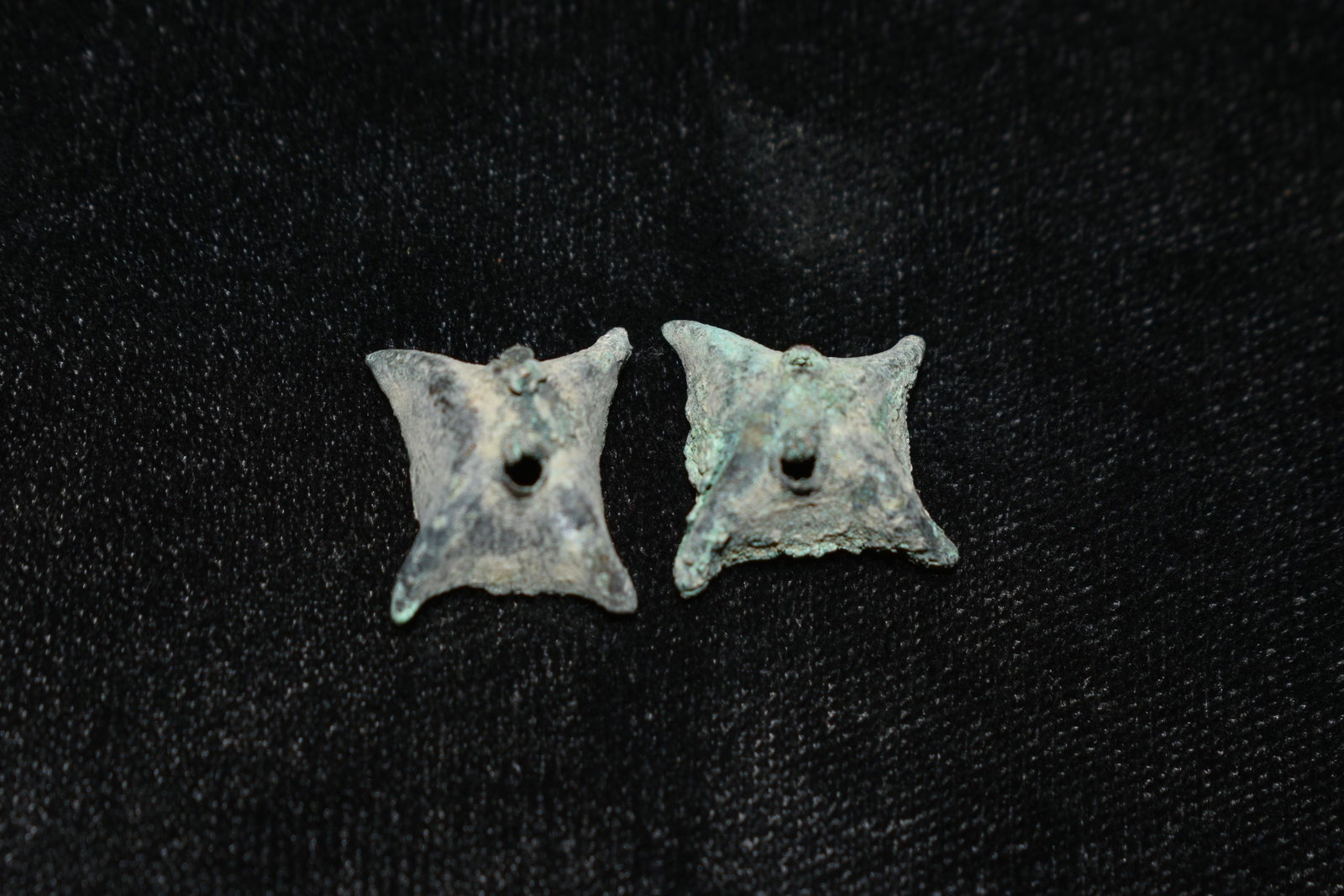 A pair of Chimu-Inca copper mantle ornaments from Peru,: A pair of Chimu-Inca copper mantle ornaments from Peru, ca. 1100 â€“ 1450 AD. These fine star-shape examples are 3/4” in diameter and have strong mineral deposits.