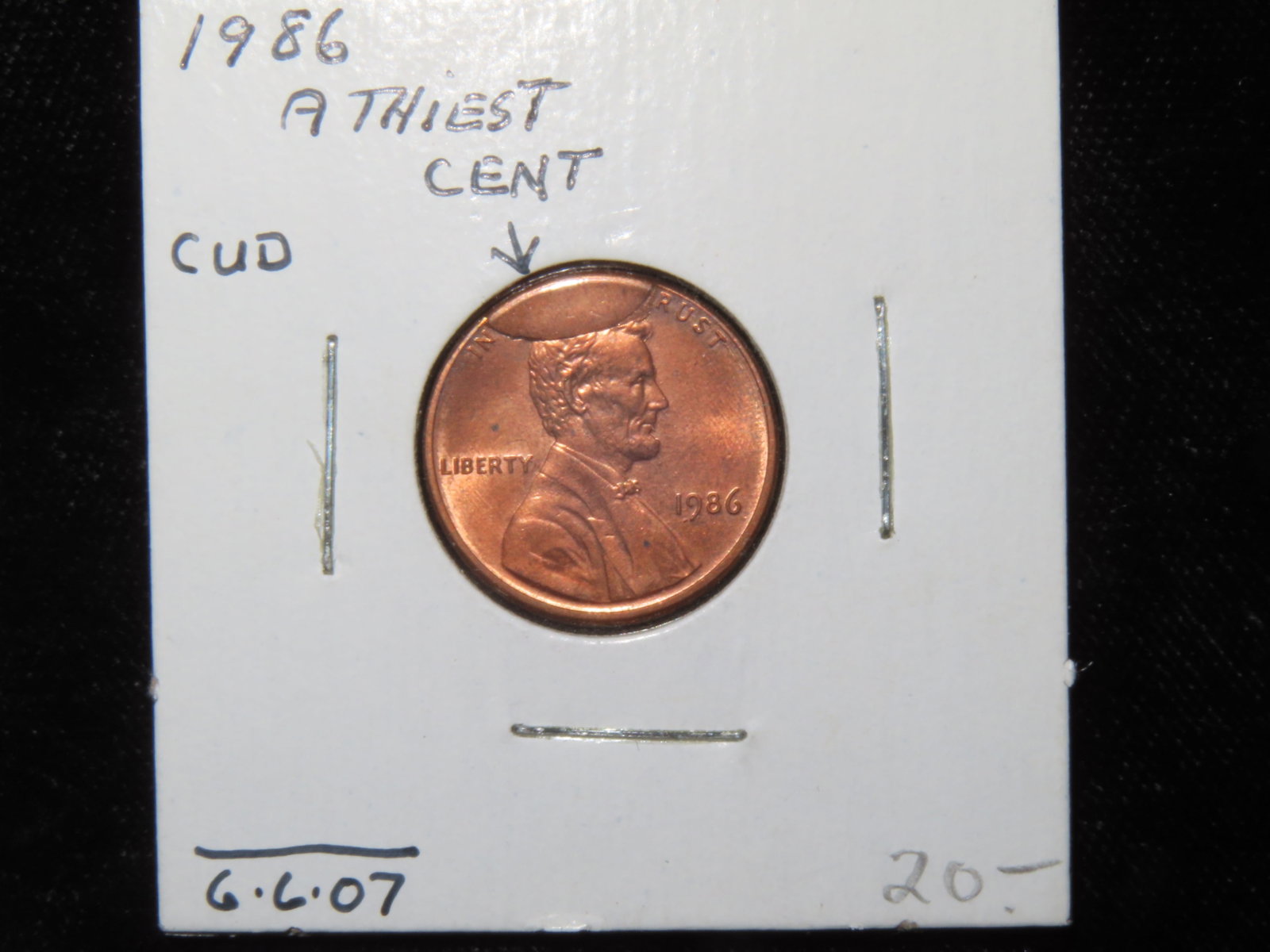 1986 United States of America Lincoln Penny, "Atheist Cent", Rim Cud- A cud on a coin is a damaged: 1986 United States of America Lincoln Penny, "Atheist Cent", Rim Cud- A cud on a coin is a damaged area resembling a blob on the surface of a coin. The cud is raised above the field, obliterating the 