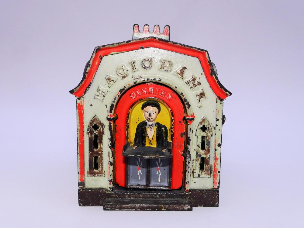 J E STEVENS CAST IRON MAGIC BANK: J E STEVENS CAST IRON MAGIC BANK, ALL ORIGINAL, OPEN THE DOOR SO THE CASHIER IS FACING FORWARD PLACE A COIN ON THE TRAY AND PRESS THE KNOB.THE DOOR WILL FLIP CLOSE AND DEPOSIT THE COIN.5 X 4 X 4