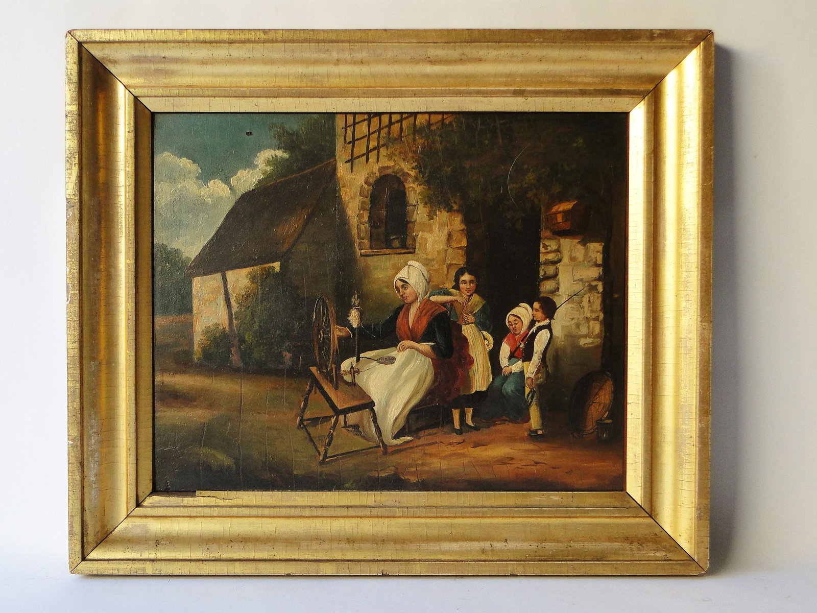 19TH C O/B PAINTING EXTERIOR SCENE: 19TH C O/B PAINTING EXTERIOR SCENE, MOTHER AT SPINNING WHEEL WITH CHILDREN, BOY HOLDING FISHING POLE AND FISH, 13.6 X 16.8 / 19 X 22.5 FRAME